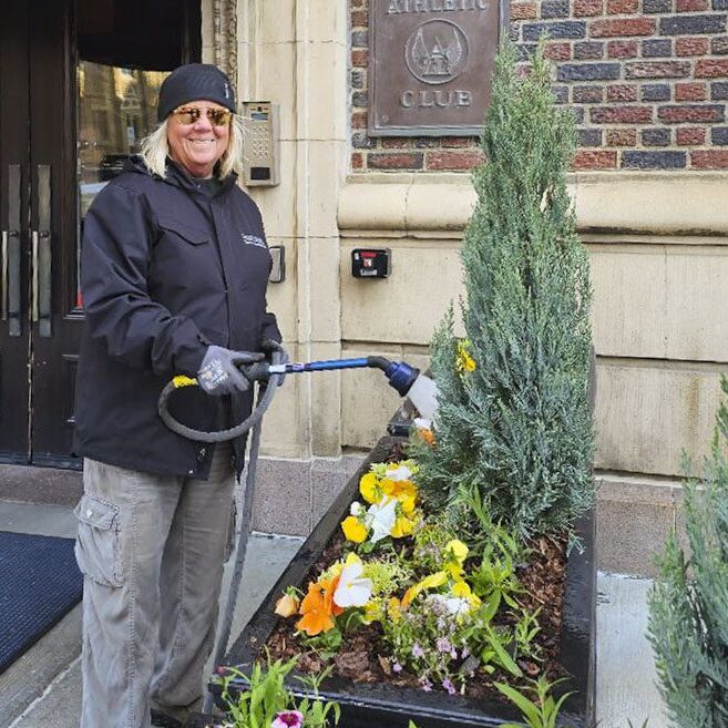 Watering exterior plants in downtown Columbus.